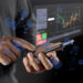 A person uses a smartphone displaying a floating digital interface with stock market charts, buy and sell buttons, and financial data against a dark background with blue light effects. | ZIIMP